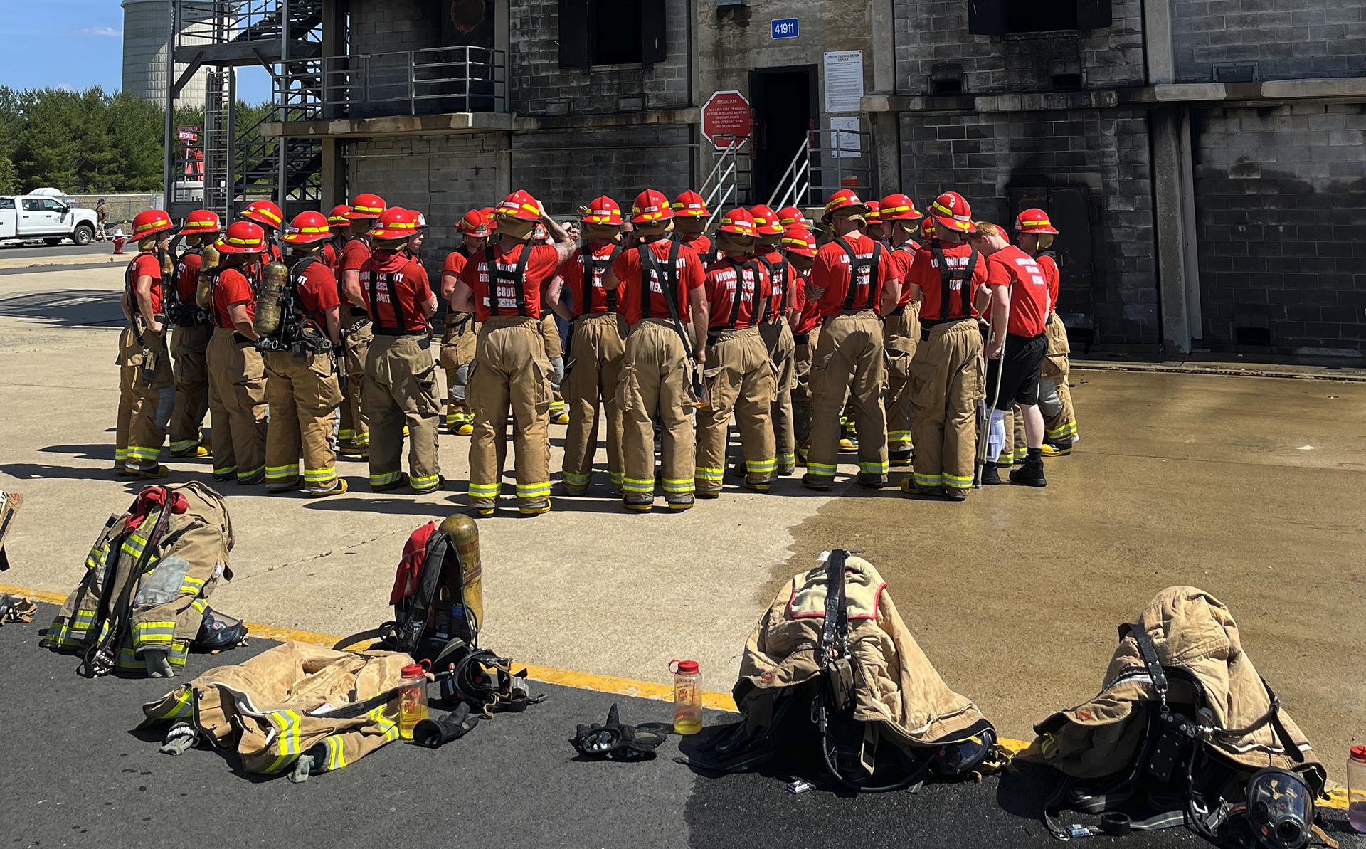 Firefighters gathered in training yard with gear laid out
